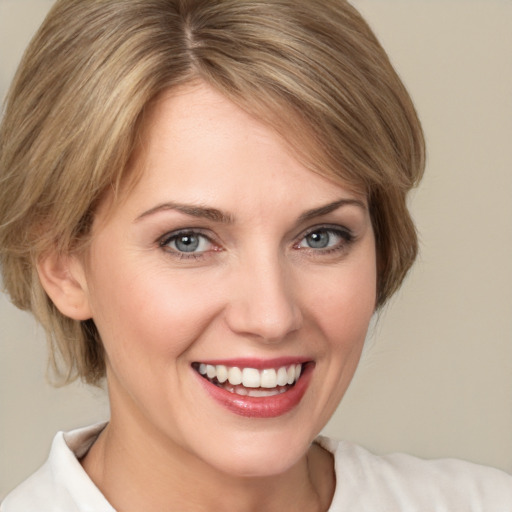 Joyful white young-adult female with medium  brown hair and green eyes