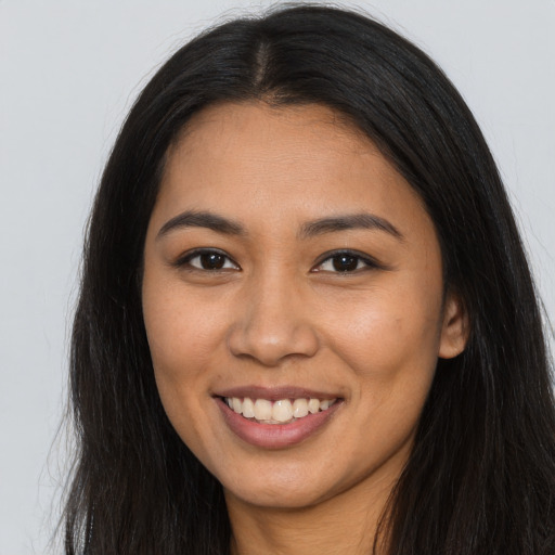Joyful latino young-adult female with long  brown hair and brown eyes
