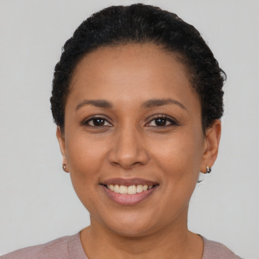 Joyful latino young-adult female with short  black hair and brown eyes