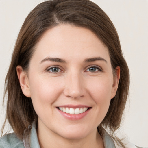 Joyful white young-adult female with medium  brown hair and grey eyes