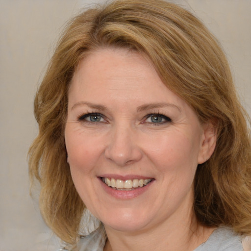 Joyful white adult female with medium  brown hair and blue eyes