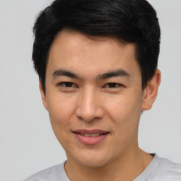 Joyful asian young-adult male with short  brown hair and brown eyes