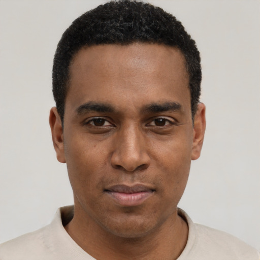 Joyful black young-adult male with short  black hair and brown eyes