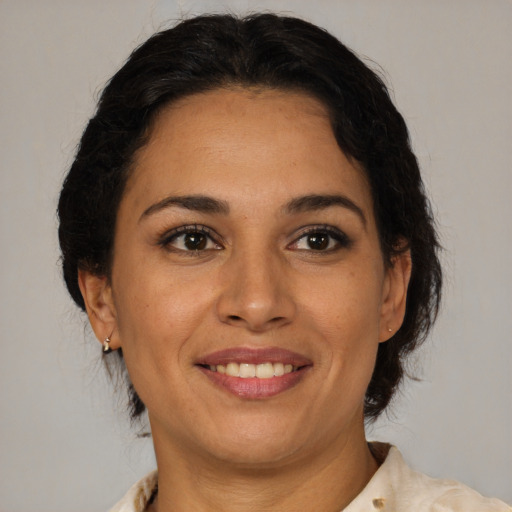 Joyful latino adult female with medium  brown hair and brown eyes