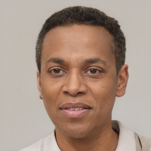 Joyful black adult male with short  black hair and brown eyes