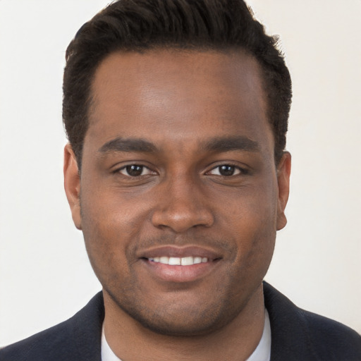 Joyful black young-adult male with short  brown hair and brown eyes