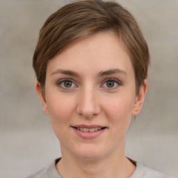 Joyful white young-adult female with short  brown hair and grey eyes