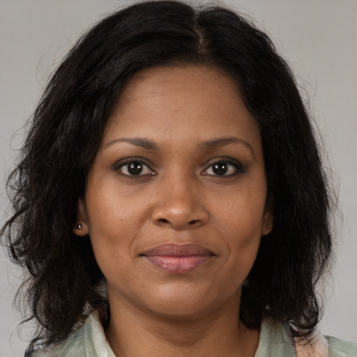 Joyful black adult female with medium  brown hair and brown eyes
