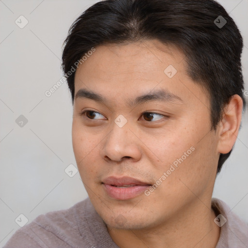 Joyful asian young-adult male with short  brown hair and brown eyes