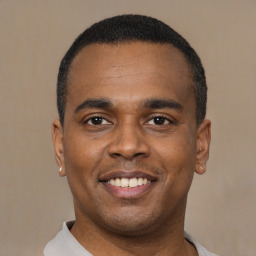 Joyful latino young-adult male with short  black hair and brown eyes