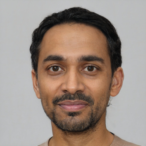 Joyful latino adult male with short  black hair and brown eyes
