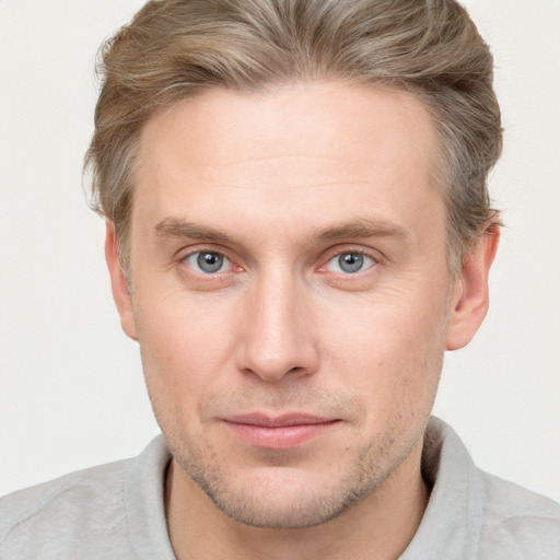 Joyful white young-adult male with short  brown hair and blue eyes