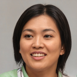 Joyful asian young-adult female with medium  brown hair and brown eyes