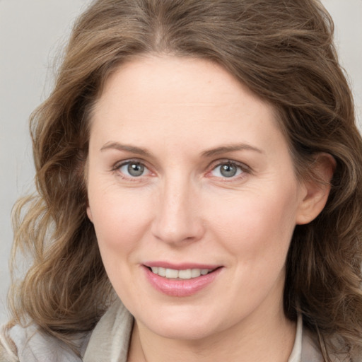 Joyful white adult female with medium  brown hair and grey eyes