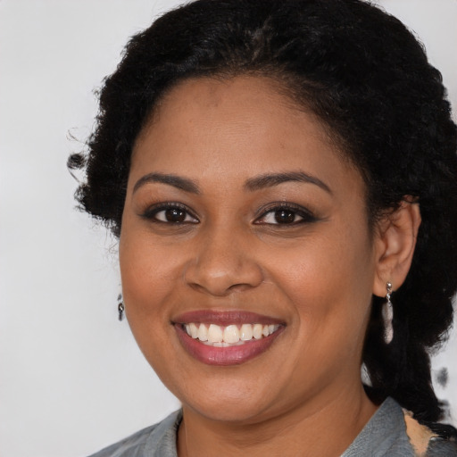 Joyful black young-adult female with medium  brown hair and brown eyes