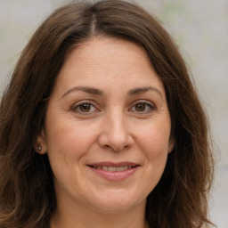 Joyful white adult female with long  brown hair and brown eyes