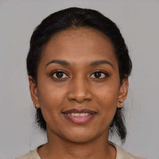 Joyful black young-adult female with short  black hair and brown eyes