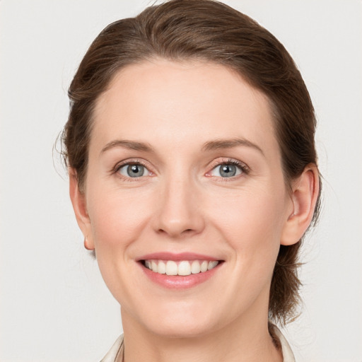 Joyful white young-adult female with medium  brown hair and blue eyes