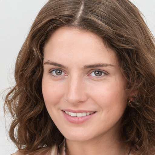 Joyful white young-adult female with long  brown hair and green eyes