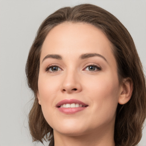 Joyful white young-adult female with long  brown hair and green eyes