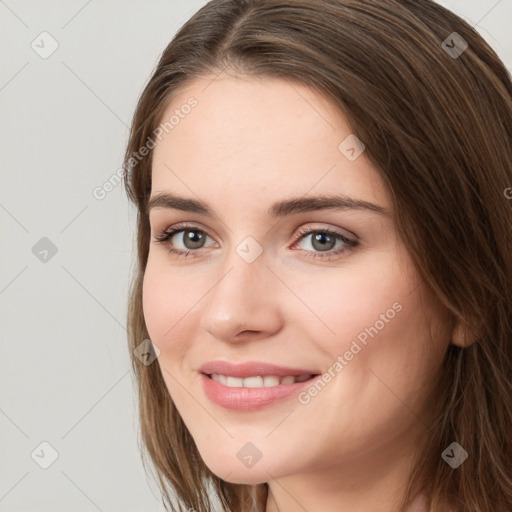 Joyful white young-adult female with long  brown hair and grey eyes