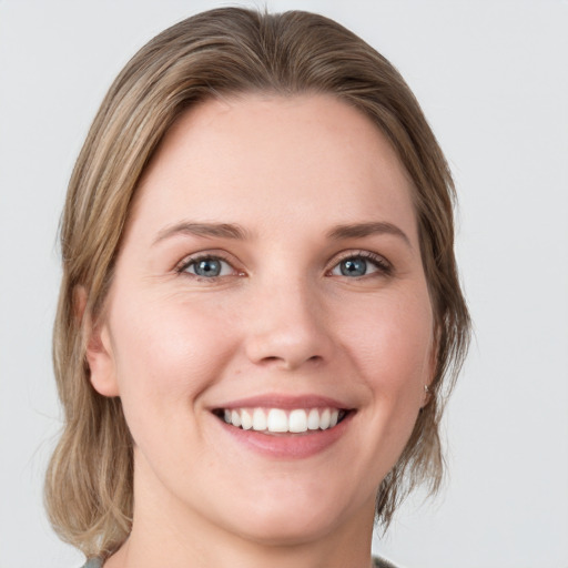 Joyful white young-adult female with medium  brown hair and green eyes