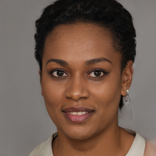 Joyful black young-adult female with short  black hair and brown eyes