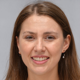 Joyful white young-adult female with long  brown hair and grey eyes