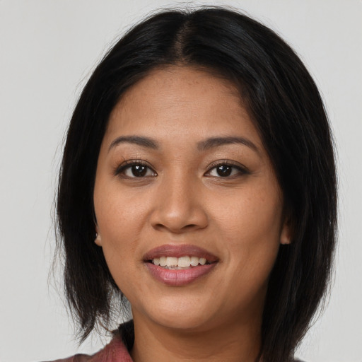 Joyful latino young-adult female with long  black hair and brown eyes