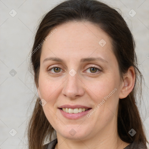 Joyful white adult female with long  brown hair and grey eyes