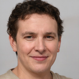 Joyful white adult male with short  brown hair and brown eyes