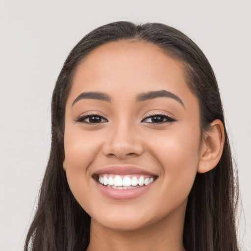 Joyful latino young-adult female with long  black hair and brown eyes