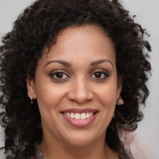Joyful black young-adult female with medium  brown hair and brown eyes