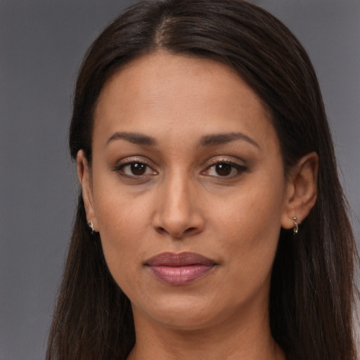 Joyful black adult female with long  brown hair and brown eyes