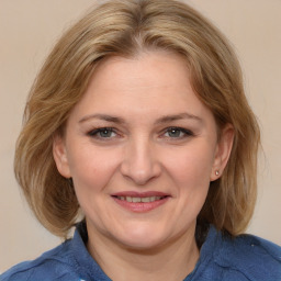 Joyful white young-adult female with medium  brown hair and blue eyes