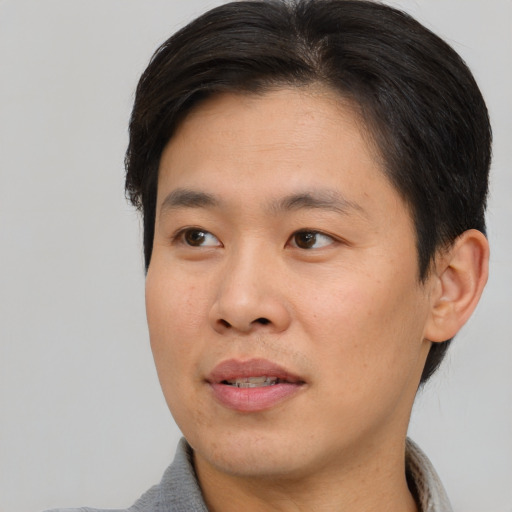 Joyful asian young-adult male with short  black hair and brown eyes