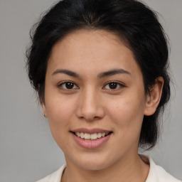 Joyful latino young-adult female with medium  brown hair and brown eyes