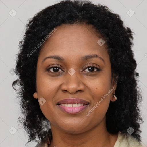 Joyful black young-adult female with long  brown hair and brown eyes