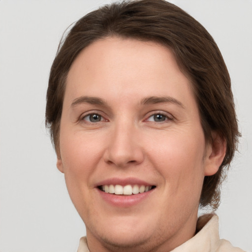 Joyful white young-adult female with short  brown hair and grey eyes