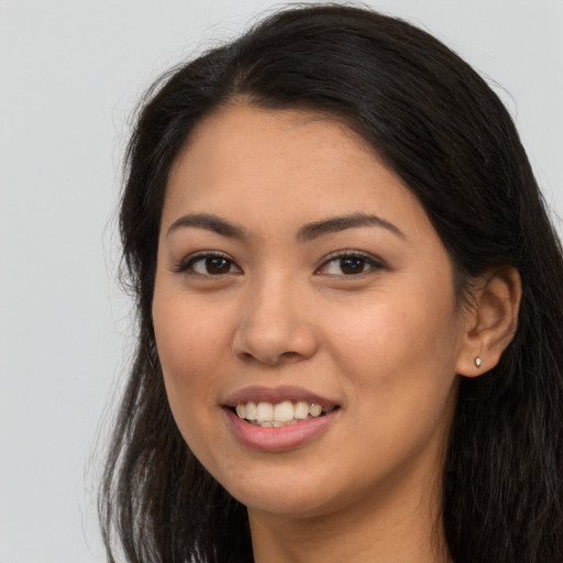 Joyful latino young-adult female with long  brown hair and brown eyes