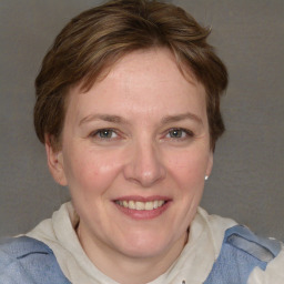 Joyful white adult female with medium  brown hair and blue eyes