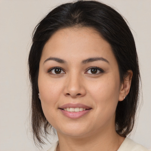 Joyful latino young-adult female with medium  brown hair and brown eyes