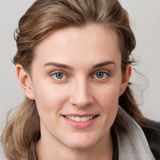 Joyful white young-adult female with medium  brown hair and blue eyes