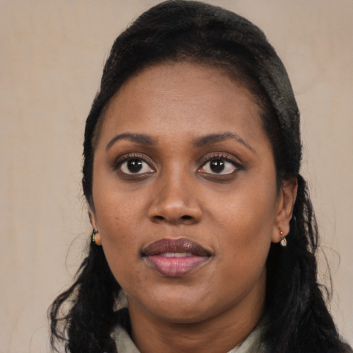 Joyful black young-adult female with long  black hair and brown eyes