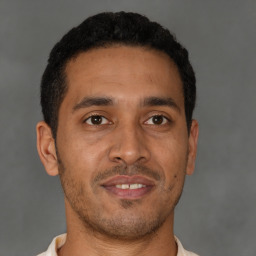 Joyful latino young-adult male with short  brown hair and brown eyes