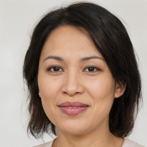 Joyful latino adult female with medium  brown hair and brown eyes