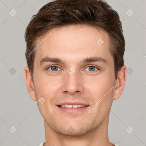 Joyful white young-adult male with short  brown hair and grey eyes