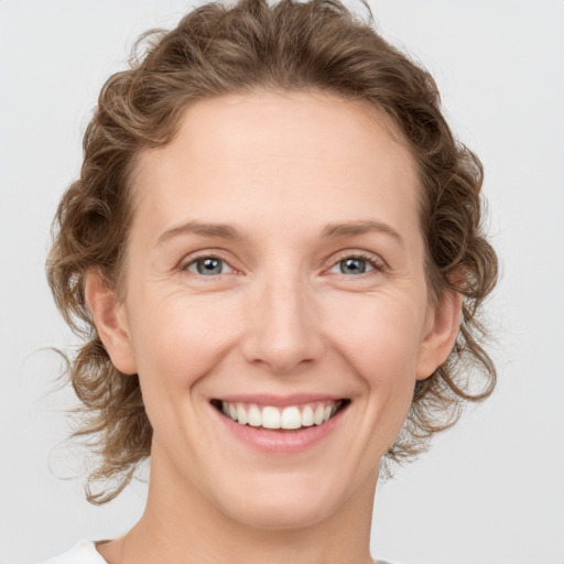 Joyful white young-adult female with medium  brown hair and blue eyes