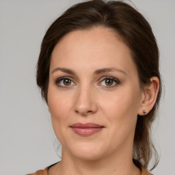 Joyful white young-adult female with medium  brown hair and grey eyes