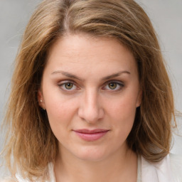 Joyful white young-adult female with medium  brown hair and green eyes